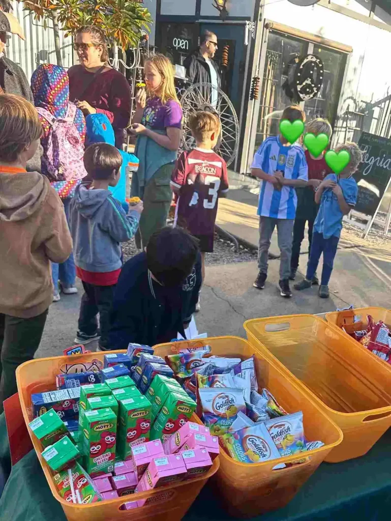 Children gather around snacks and drinks at an outdoor event hosted by Fairytales Bookstore Nashville