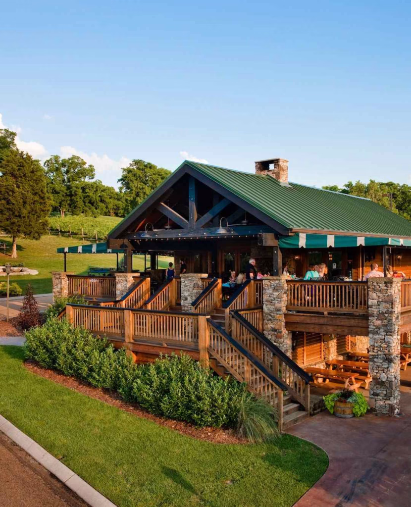 An inviting restaurant with a large outdoor deck and green roof, a charming spot to visit near Nashville in November.