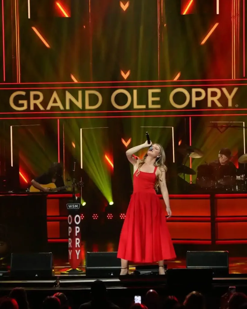 A female singer in a red dress performing at the Grand Ole Opry, a top choice for unique things you can only do in Nashville. 