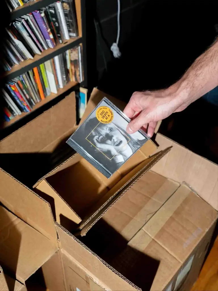 Grimeys Nashville: Vinyl, Records & Music City Treasures A hand places an old CD into a cardboard box of media at Grimey's Nashville record store