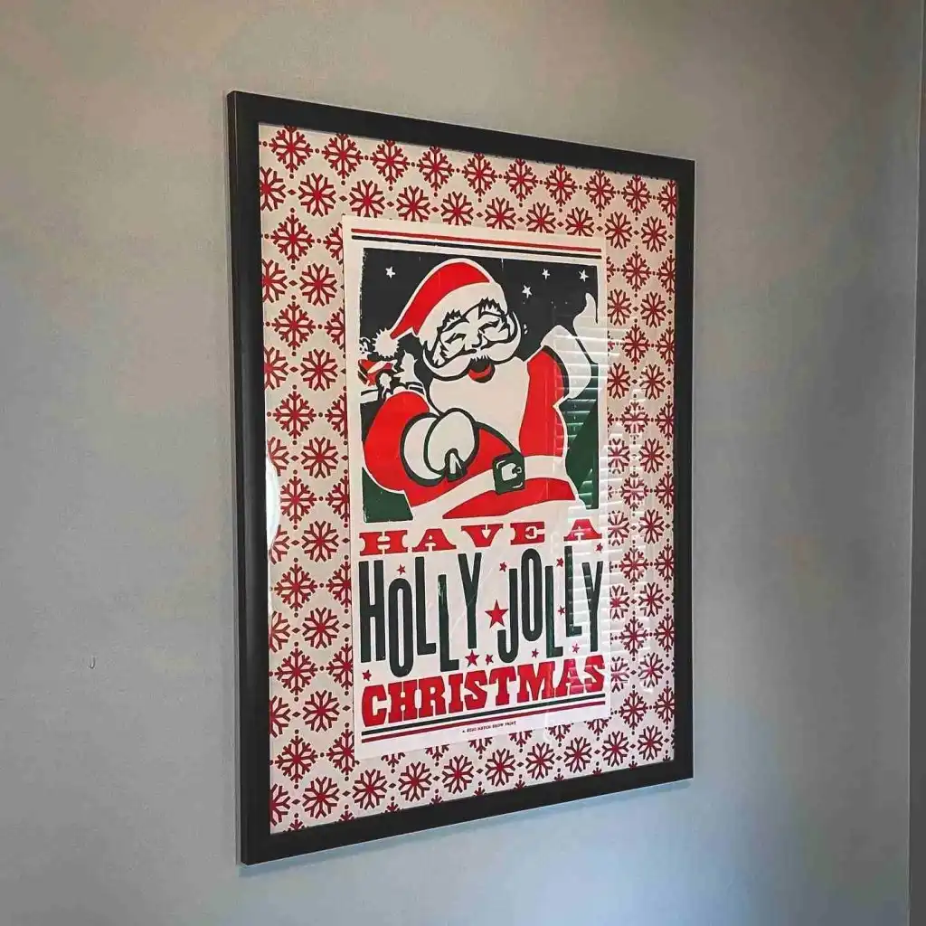 A framed, vintage-style Hatch Show Print poster with Santa, saying "Have a Holly Jolly Christmas," perfect for unique things you can only do in Nashville. 