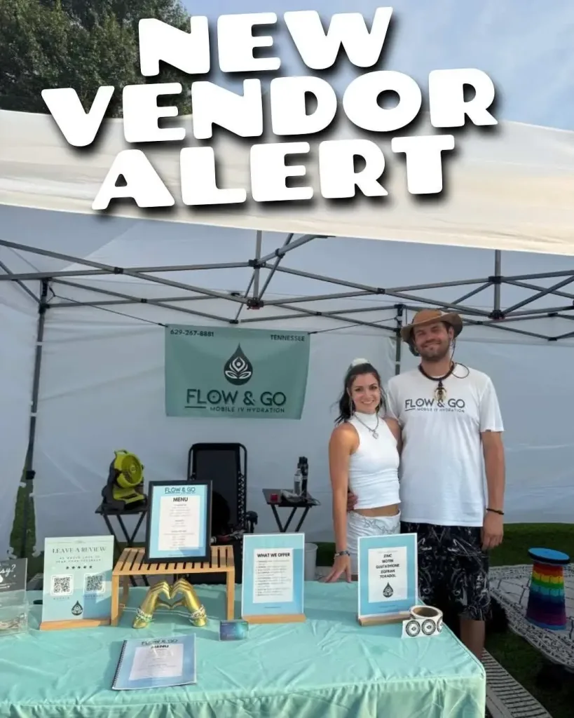 Two vendors pose in front of their "Flow & Go" IV Hydration booth at the East Nashville Farmers Market