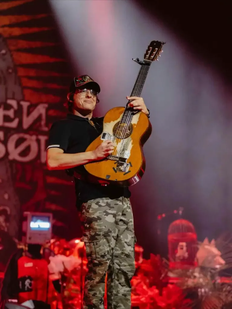 A musician holding an acoustic guitar on stage, capturing the spirit of unique things you can only do in Nashville.