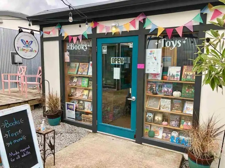 The quaint teal doorway and window displays of children's books at Fairytales Bookstore Nashville