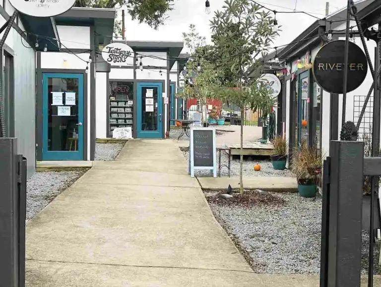 The outdoor courtyard with gravel and concrete walkway leads to Fairytales Bookstore Nashville