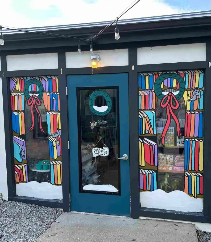 The festive, painted windows featuring books and wreaths mark the entrance to Fairytales Bookstore Nashville