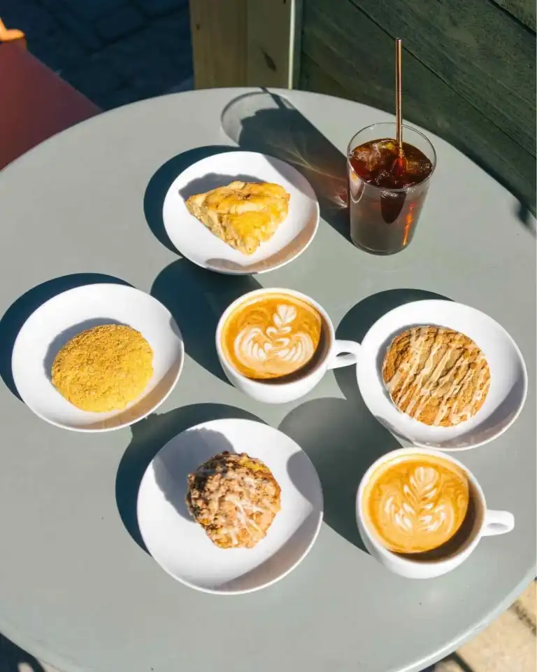 A selection of lattes, pastries, and an iced coffee on a table at Flora and Fauna Nashville