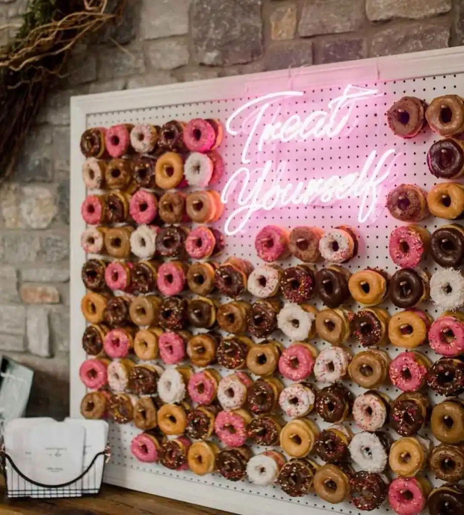 A donut pegboard wall with a pink neon "Treat Yourself" sign at Fox's Donut Den Nashville.