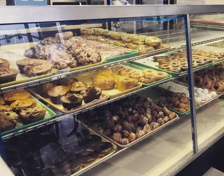 A fully stocked display case filled with donuts, fritters, and muffins at Fox's Donut Den Nashville. 