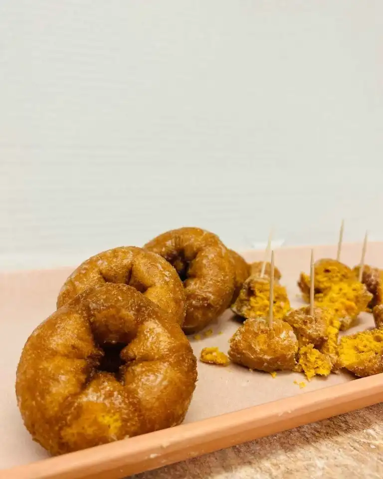 Three classic glazed buttermilk donuts and donut pieces on a tray from Fox's Donut Den Nashville
