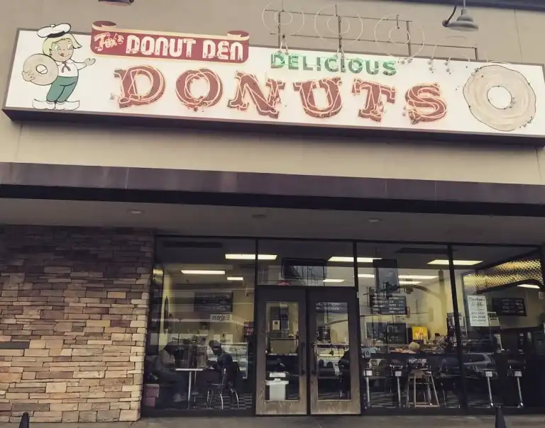 The exterior sign for Fox's Donut Den Nashville, featuring a donut mascot and a retro design. 