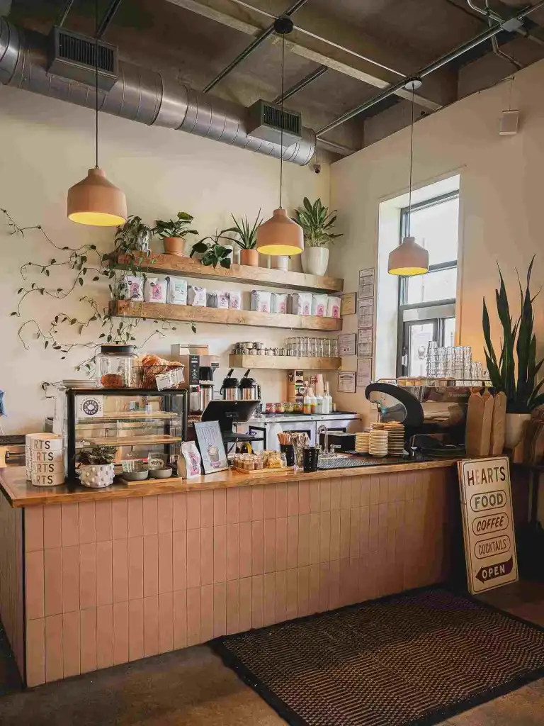 The counter area of Hearts Nashville, featuring a pastry case, espresso machine, and retail shelving.
