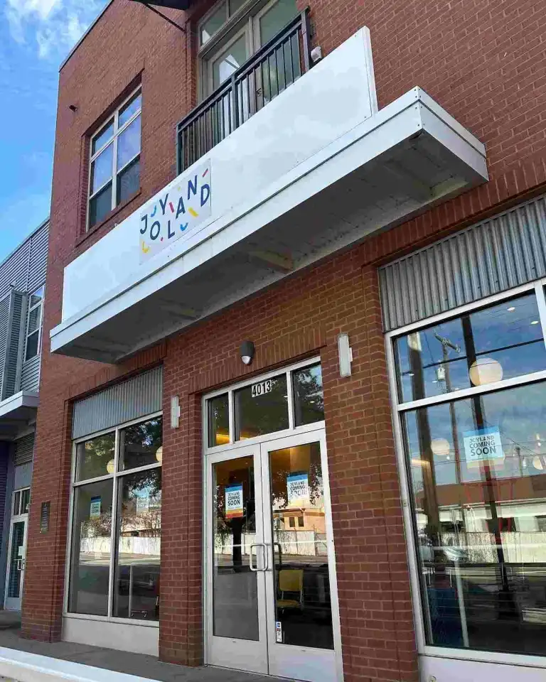 The brick exterior of Joyland Nashville at 4013 Charlotte Avenue, with "Coming Soon" signs