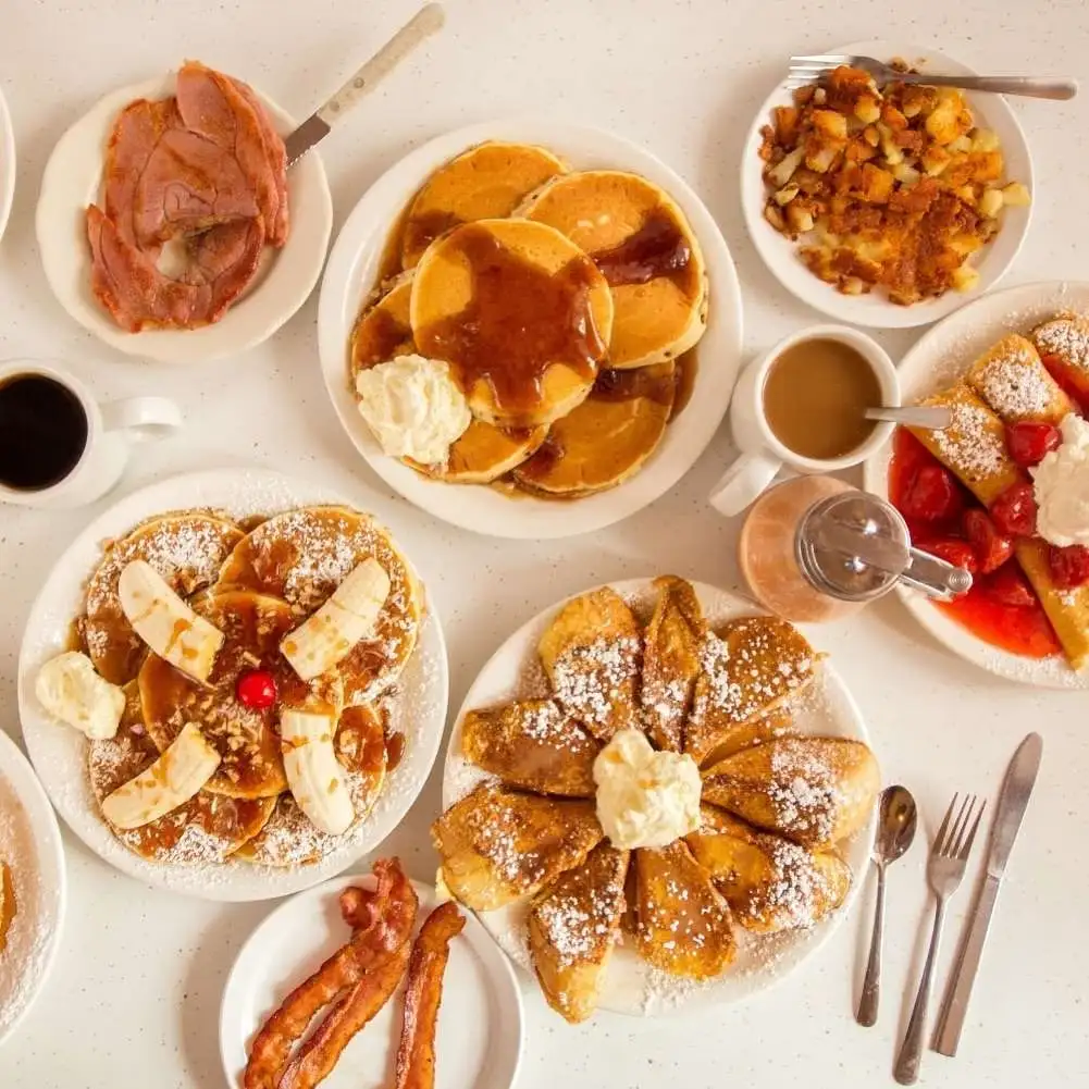 A full table of pancakes, ham, bacon, and breakfast items from Pancake Pantry Nashville