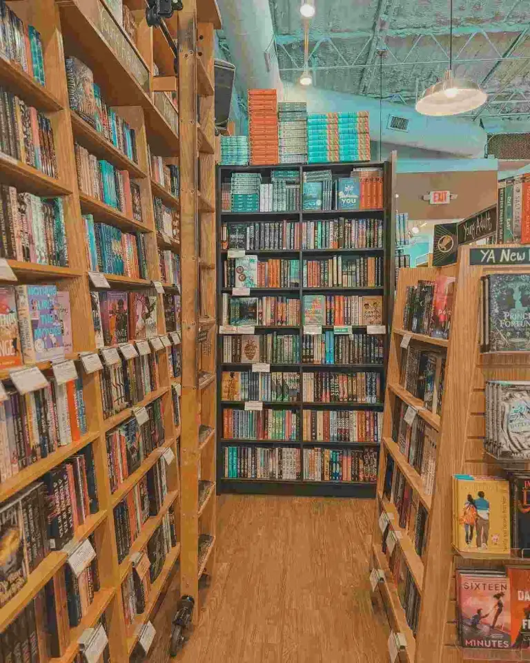 Tall wooden bookshelves filled with fiction books at Parnassus Books Nashville.