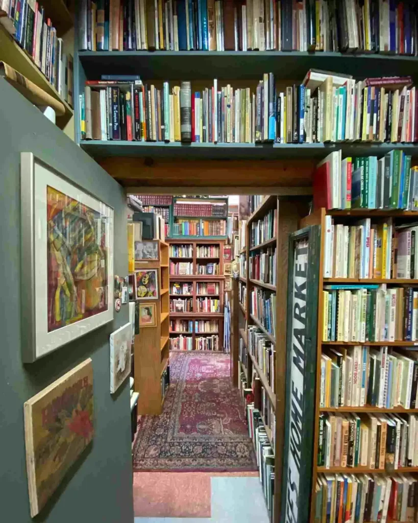 A sage green cabinet sits next to white bookshelves inside one of the Best Bookstores in Nashville