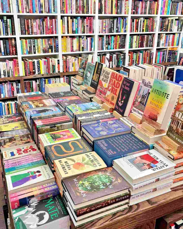 A wide variety of books stacked on display tables fill the interior of The Bookshop Nashville.
