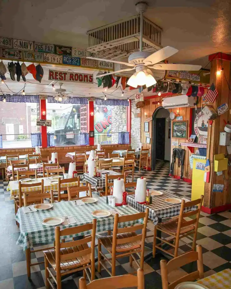 The checkerboard floor and wooden chairs of the dining room at Uncle Bud's Nashville.