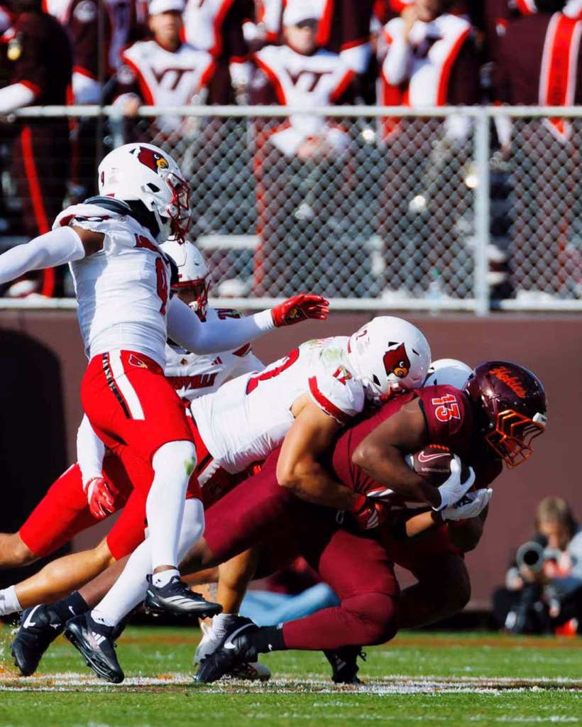 Louisville players tackle Vanderbilt runner during Nashville in May football game.