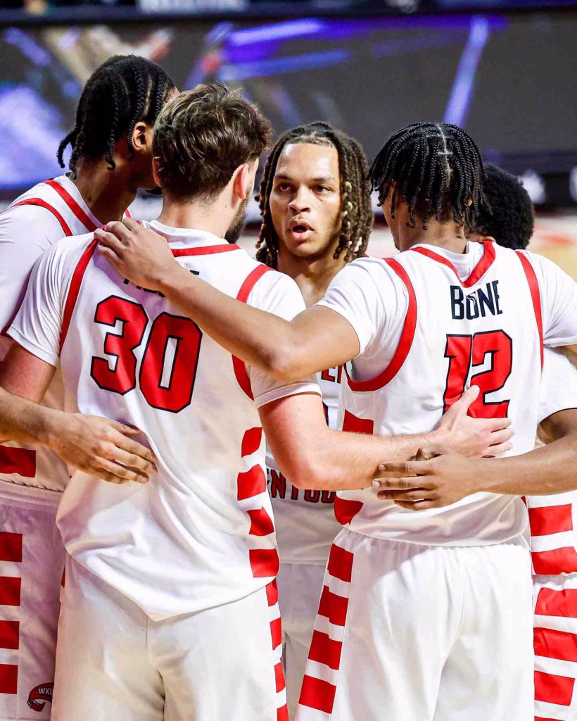 Basketball team huddles during intense game in Nashville in January, showing unity, focus, and teamwork.