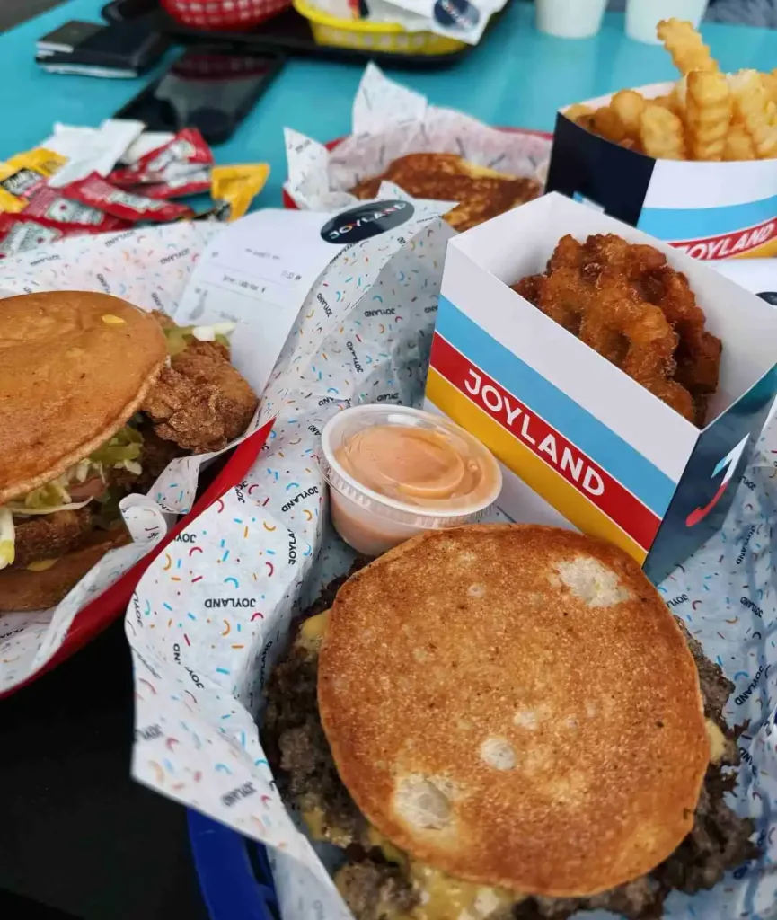 A table full of burgers, fries, and chicken nuggets from Joyland Nashville restaurant