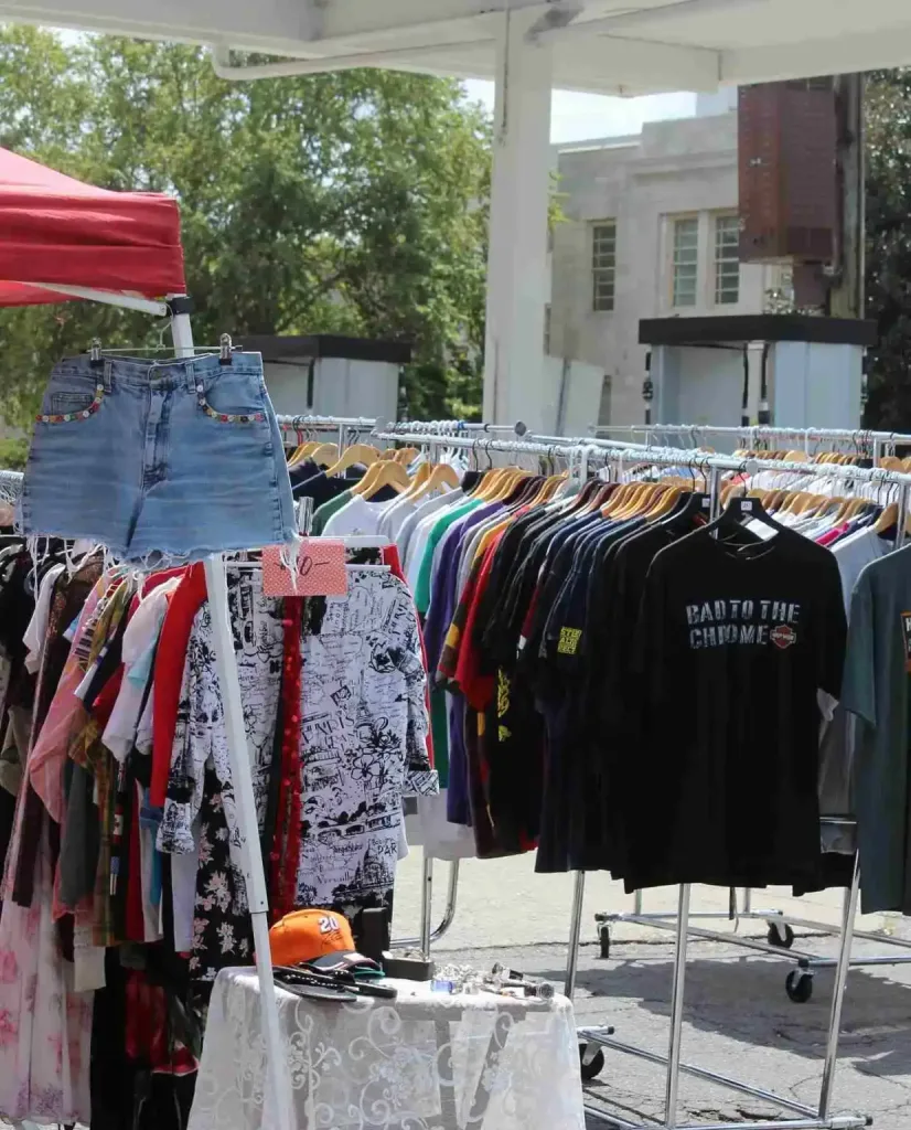 East Nashville Summer Bucket List Guide Racks of colorful vintage clothing and denim shorts at an outdoor market, a classic East Nashville Summer Bucket List item.