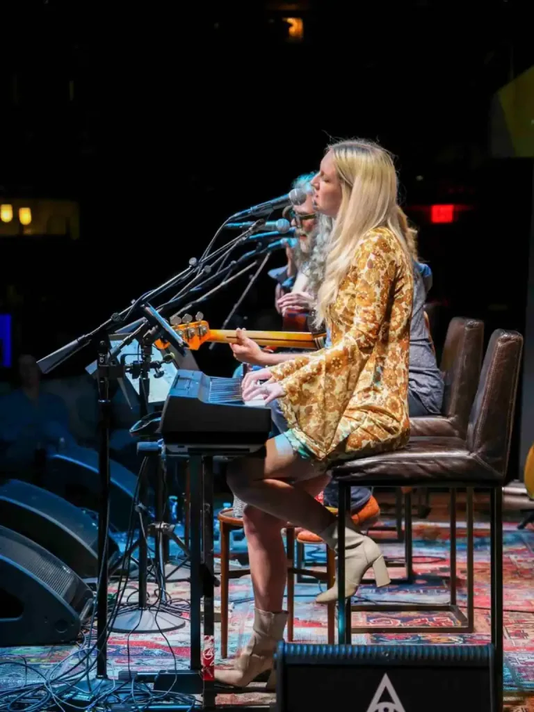 East Nashville Summer Bucket List Guide A blonde woman playing a keyboard and singing in an intimate venue, a great East Nashville Summer Bucket List activity.
