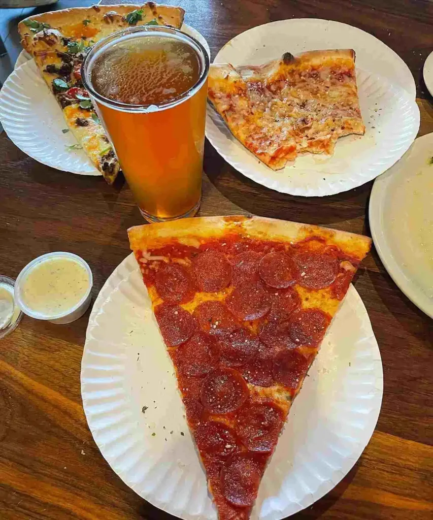 East Nashville Summer Bucket List Guide Large slices of New York style pizza and a beer, a must-try item on the East Nashville Summer Bucket List.